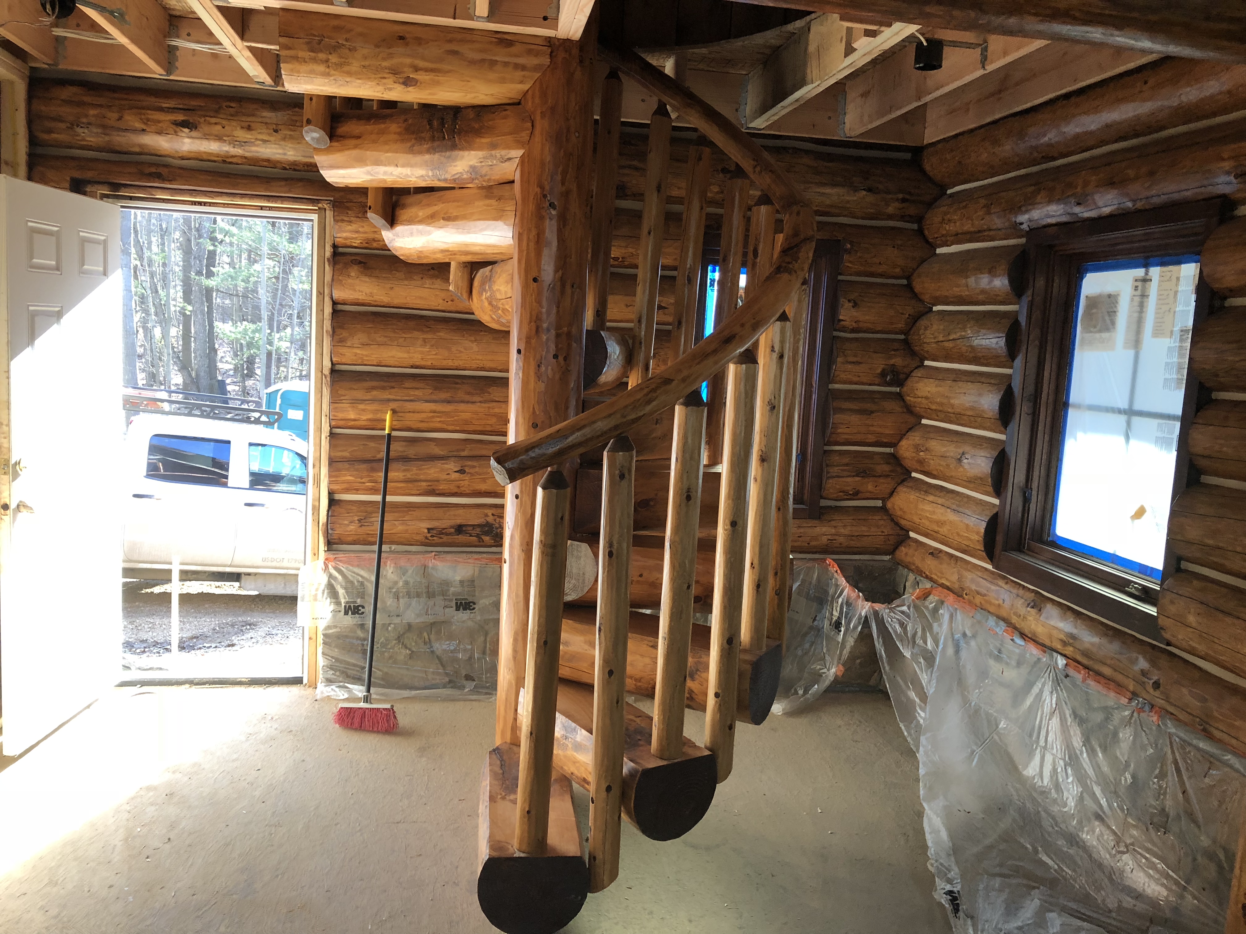 Spiral log staircase pre-stained English Chestnut. Rustic railing